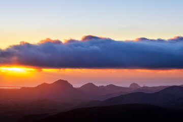 Obraz premium Sunset with clouds and mountains in silhouette