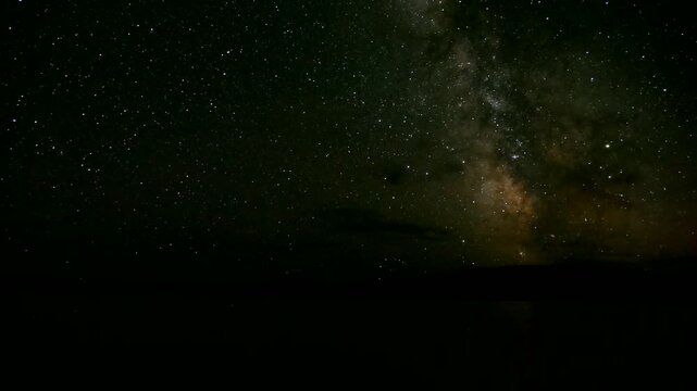 The night lake against the backdrop of low mountains and the milky way, time lapse. Summer warm Mongolian night, time lapse.
