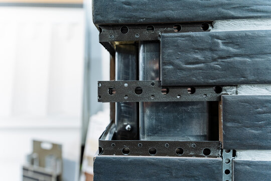 Layered Panel Edges Secured With Steel Brackets And Screws Workshop Settings. Display Of Layered Panels With Perforated Brackets And Fasteners In Industrial Workshop Environment