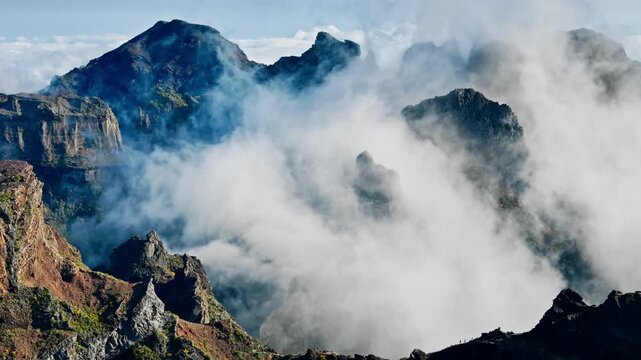 Fast drifting clouds covering mountain valleys near Pico do Arieiro, Madeira Island, drone view