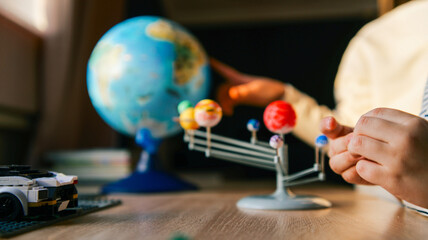 Fototapeta premium Child learning about planets and solar system with educational toys and globe