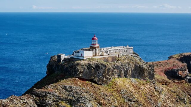 Lighthouse Farol Sao Lourenco surrounded by volcanic rocks and steep coastline, eastern Madeira, aerial perspective