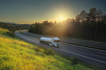 A trucks on a highway at sunset drives through a wide landscape, transporting goods © Jaroslav Pachý Sr.