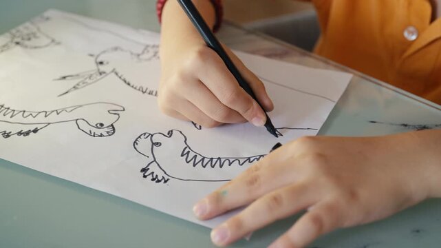 Child Hand Drawing Dinosaurus With Markers in Sketchbook, Creative Process