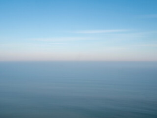 Obraz premium Blue sea and sky with a hazy horizon