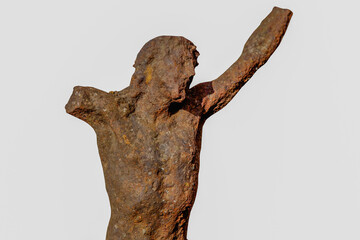 Naklejka premium Very old iron statue of the crucifixion of Jesus Christ, rough texture and aged surface, representing endurance, belief, and sacred heritage.