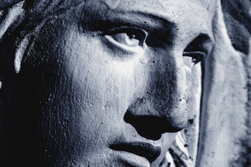 Fototapeta premium Dramatic side portrait of Virgin Mary sculpture, focusing on powerful eyes, inner pain, devotion, and timeless sacred emotion.