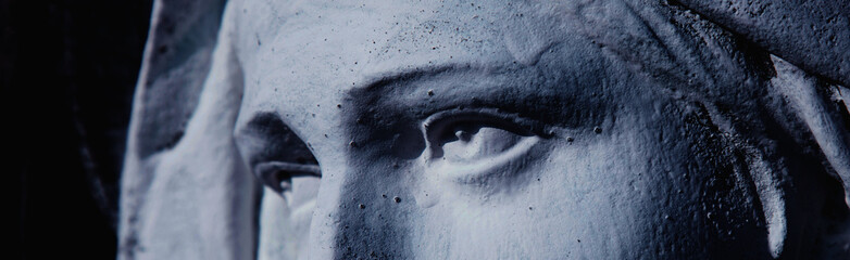 Naklejka premium Monochrome close-up of Virgin Mary sculpture focusing on powerful eyes, inner pain, devotion, and timeless sacred emotion.