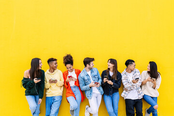 Multiracial young friends having fun sharing media content on mobile phone. Communication and social media concept