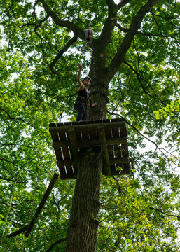 Happy woman celebrating success on high ropes course platform