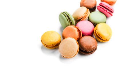 Obraz premium Macarons, macaroons, colorful assortment border design, vibrant pink, yellow, green, brown French pastries creamy fillings, macaroon isolated on white background, gourmet dessert. Close up 