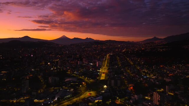 Aerial view of Quito at sunrise with Cotopaxi Volcano prominently featured in the background.