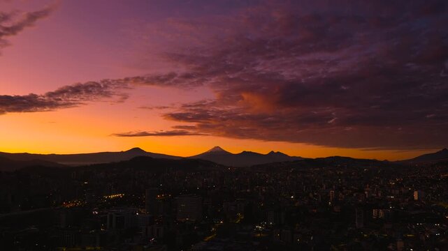 Quito, Ecuador: Sunrise over the city with the Cotopaxi volcano visible in the background.