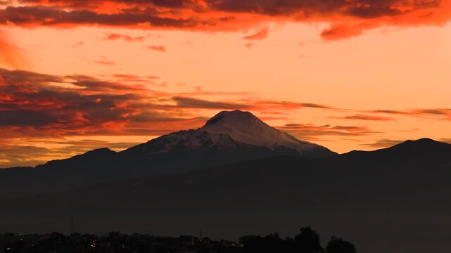Quito, Ecuador: Cayambe volcano at sunrise, with its peak shrouded by clouds.