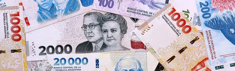 Argentine peso money bills pile on table. Argentina banknotes of ARS currency close up.