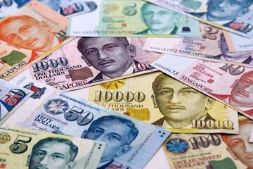 Singapore dollar money bills pile on table. Singapore banknotes of SGD currency close up.
