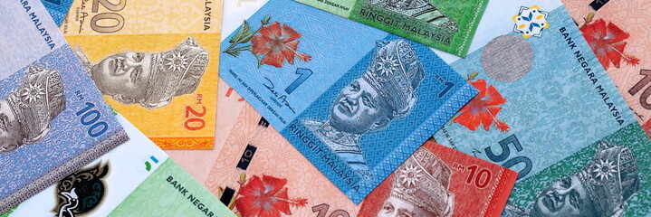 Malaysian ringgit money bills pile on table. Malaysia banknotes of MYR currency close up. © Larysa