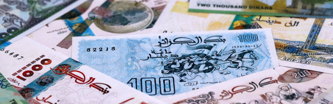Algerian dinar money bills pile on table. Algeria banknotes of DZD currency close up.