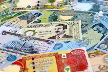 Fototapeta premium Iraqi dinar money bills pile on table. Iraq banknotes of IQD currency close up.