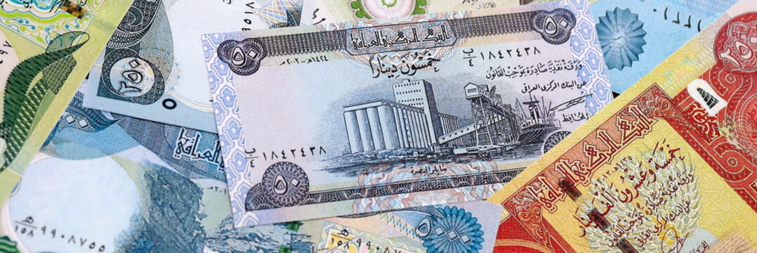 Iraqi dinar money bills pile on table. Iraq banknotes of IQD currency close up.