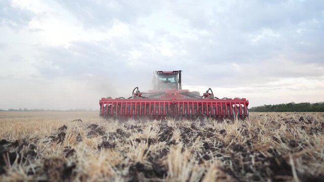 Work of tractor on field. Agricultural work on ground. tractor works on an organic field. Fertilizer fertile soil. Soil preparation for sowing crops. farmer on tractor cultivates fertilizes land.