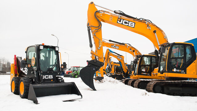 Riga, Latvia - February 7, 2026: New JCB excavators and a mini bulldozer on the street near the auto center in winter