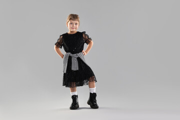 Fashion. Cute little girl in stylish outfit on light grey background, space for text