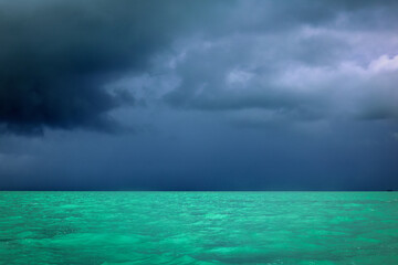 Scenic landscape of the turquoise sea of the Indian Ocean and distant stormy clouds near Rodrigues...