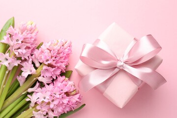 Fototapeta premium Beautiful hyacinth flowers and gift box on pink background, flat lay