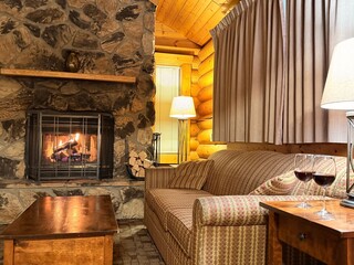 Fototapeta premium Fireplace and furniture in cozy room. Interior design