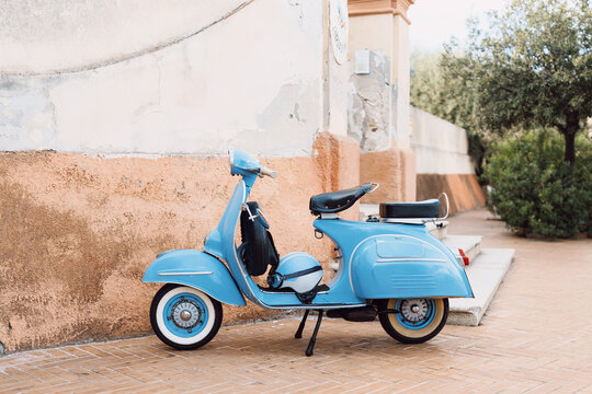 Blauer Kult-Motorroller steht an einer Stra&szlig;e in Italien 

