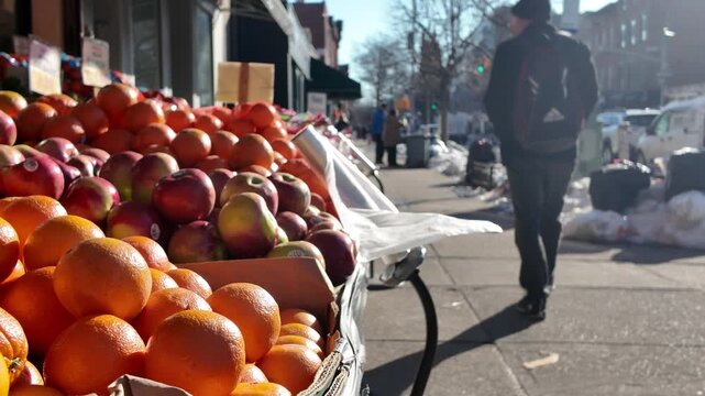 people walk past fruit displayed in front of deli in Brooklyn