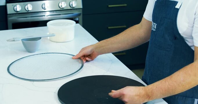 Cook showing off pizza crisper in kitchen - closeup shot