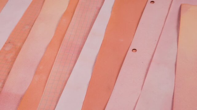 Abstract background of handmade craft paper in soft peach, coral, and salmon shades dyed with natural vegetable colorants. Textured recycled sheets with grunge edges arranged for scrapbooking.