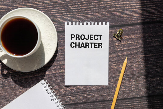 Word text Project Charter memo written on a brown craft paper as background with red pencils.