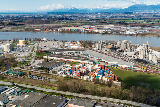 Canada, BC, Delta.  Aerial view of shipping container storage facility with LNG storage area in the background left and Cement factory on the right.  On the banks of the Fraser River
