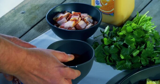 Cook's hand using fork to take food out of can and drop it into bowel