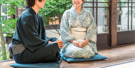 日本家屋の縁側に座る浴衣姿のアジア人カップル・夫婦