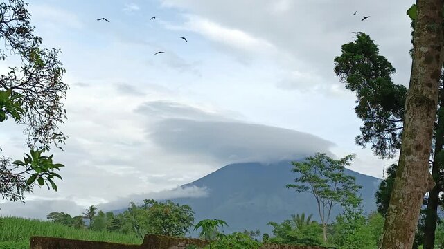 Cinematic View of Mount Arjuno with Lenticular Clouds and Swiftlets Flying in Singosari, East Java