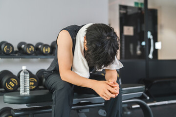 Training gym, young asian man taking a break at sports gym