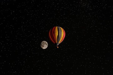 A Colorful Hot Air Balloon and Full Moon in a Starry Night Sky