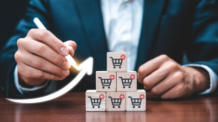 Naklejka premium Businessman drawing a glowing upward arrow with a pen next to stacked online shopping cart blocks symbolizing sales growth