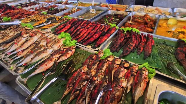 Pan left of various Malay grilled and pan fried fish sold at a local eatery in Terengganu, Malaysia. The grilled fish were normally ate with white rice and other vegetables