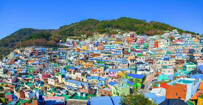 Panoramic view of colorful hillside houses at Gamcheon Culture Village overlooking Busan city and coastline, showcasing vibrant urban landscape and cultural tourism destination in South Korea.