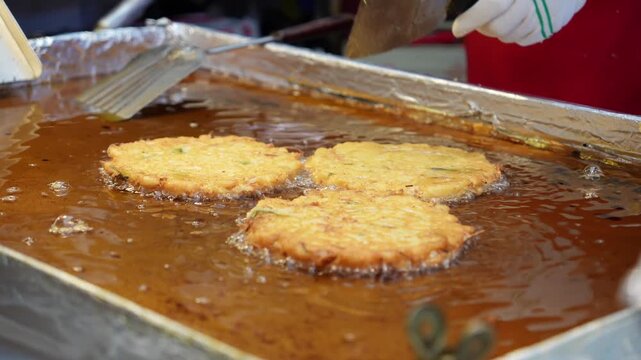 市場の屋台で緑豆チヂミを焼いているシーン
