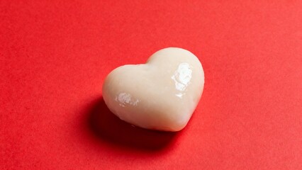 Obraz premium Heartshaped glossy object on red background
