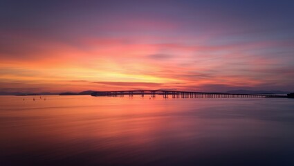 Obraz premium A vibrant sunrise over the Eau Gallie Causeway Bridge in Melbourne, Florida