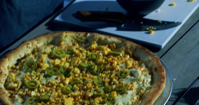 Cook spreading sauce over delicious veggie pizza - high, closeup shot