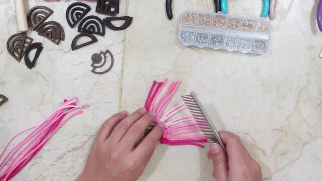 Female hands making earrings with macrame thread