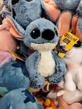 Cute Blue Plush Stitch Toy Surrounded by Other Stuffed Animals